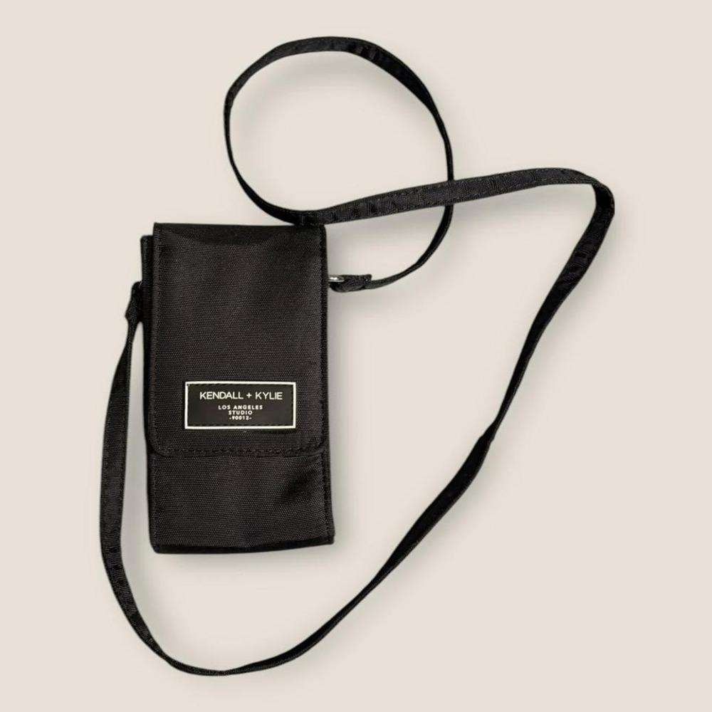 Black Kendall + Kylie crossbody phone and wallet holder with adjustable strap